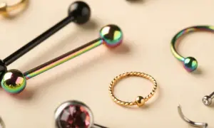 Kolekcja biżuterii do piercingu: sztangi, kółka i podkowy w tęczowych i złotych kolorach, idealne do piercingu penisa.