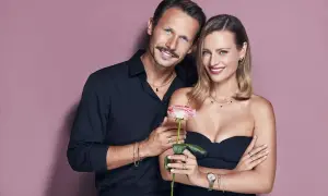 Para, która reklamuje apart, trzyma różę. Elegancka kobieta i mężczyzna w czarnych strojach prezentują biżuterię.