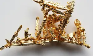 Złote kryształy o próbie 925, przypominające miniaturową architekturę, lśnią na jasnym tle. To próba 925 złoto czy srebro?