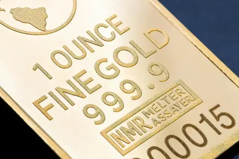 Sztabka złota z napisem "1 OUNCE FINE GOLD 999.9" i numerem seryjnym.