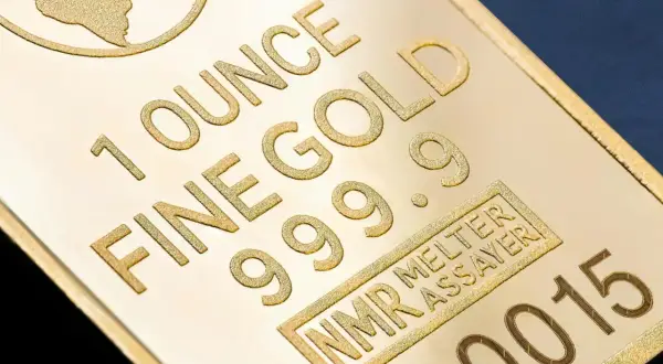 Sztabka złota z napisem "1 OUNCE FINE GOLD 999.9" i numerem seryjnym.
