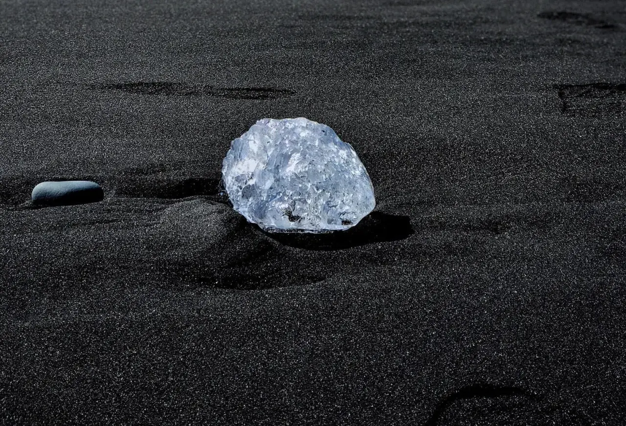 Lodowy diament na czarnym piasku. Jego zastosowanie? Czysta, naturalna piękność, jak ta na plaży.