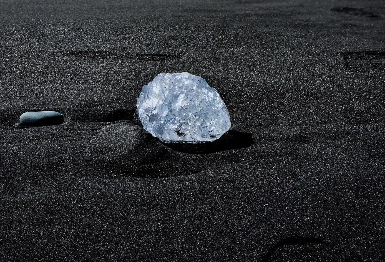 Lodowy diament na czarnym piasku. Jego zastosowanie? Czysta, naturalna piękność, jak ta na plaży.